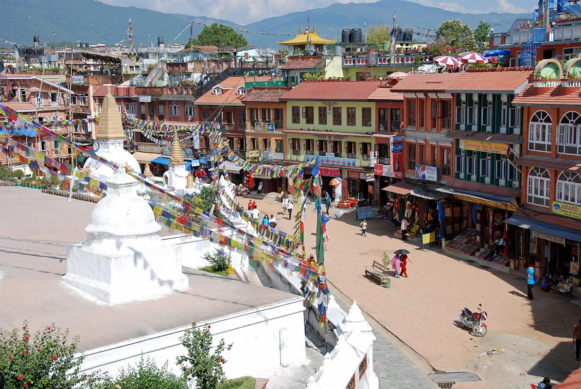 Kathmandu Boudhanath 16 End OF Boudhanath Kora With Shops Circling The Stupa Smaller white stupas, and more Tibetan Buddhist shops flank the east side of Boudhanath Stupa near Kathmandu.